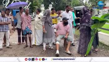 A couple protesting on a broken road in Aluva with an injured hand